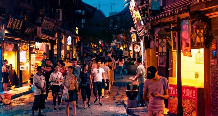 People walking down a vibrant street at dusk.