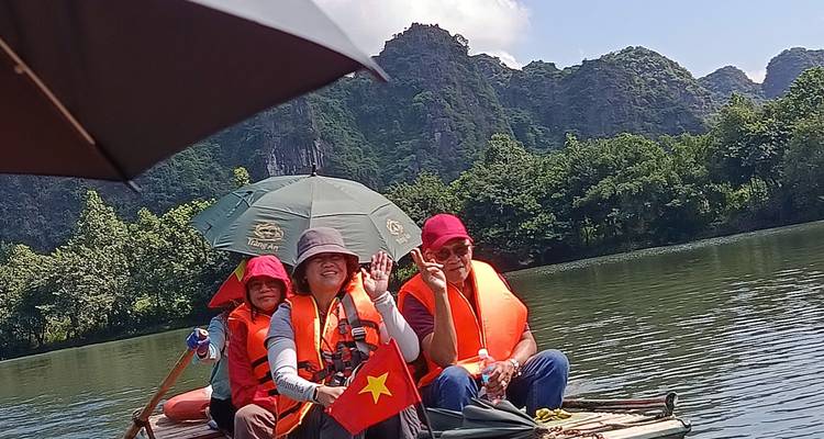 Groupe faisant signe sur un bateau avec une vue panoramique sur la rivière.