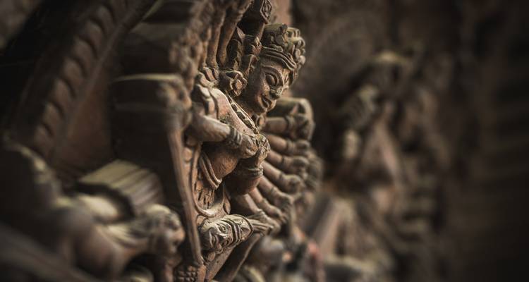 Gros plan d'une figure de divinité sculptée ornée dans un temple.