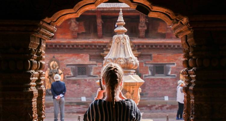 Personne photographiant des structures de temple avec des sculptures complexes.