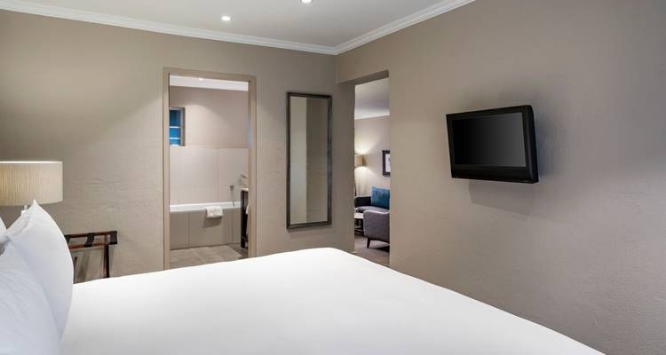 Hotel room interior with a television and bathroom entrance.