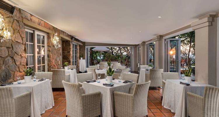 Dining area with elegant table settings and an outdoor view.