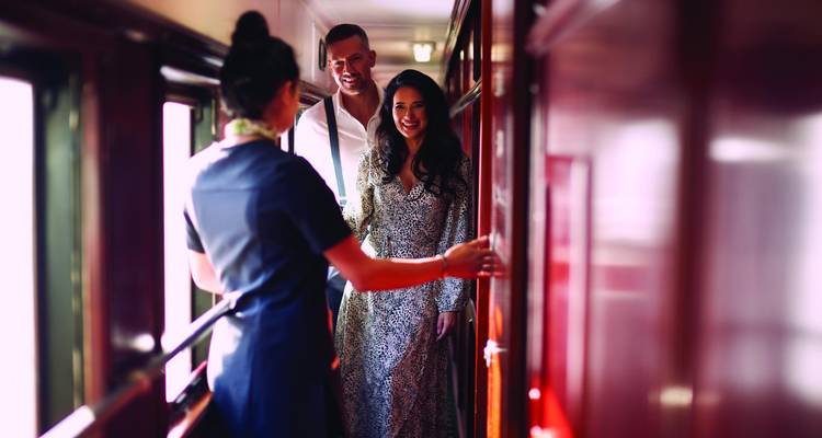 Passengers interacting in a narrow corridor of a train.