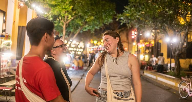 People enjoying a lively night market scene with lights.