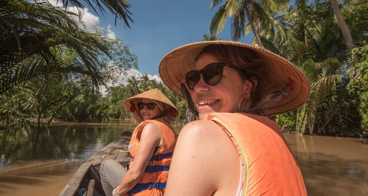 Two women on a traditional boat ride through a river.