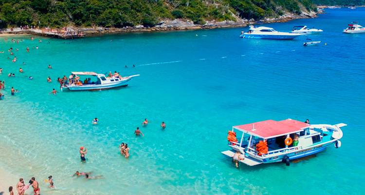Turquoise waters with boats and swimmers.
