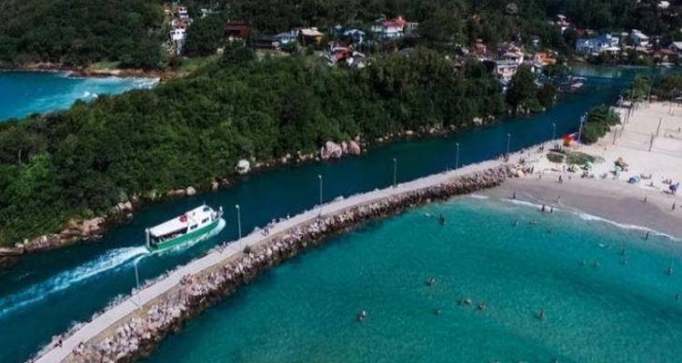 Aerial view of a river mouth with a boat and swimmers