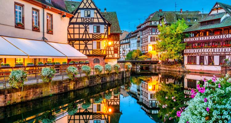 Colorful half-timbered houses along a reflective canal.