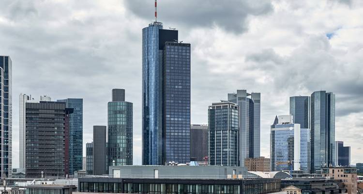 Paysage urbain avec des gratte-ciel modernes sous un ciel nuageux.