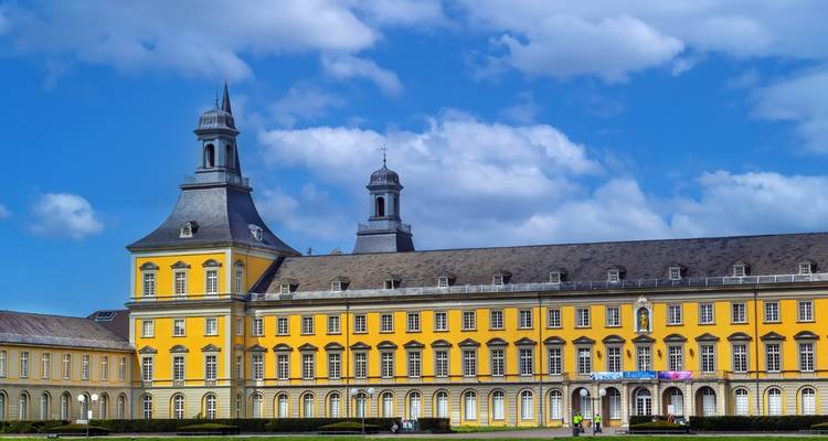 Palais jaune de style baroque sous un ciel bleu.