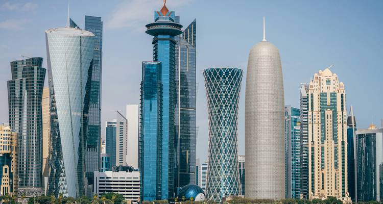 Doha skyline met moderne wolkenkrabbers en blauwe lucht.