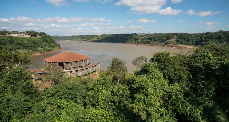 Blick auf einen großen Fluss mit einem Pavillon inmitten von Grün.