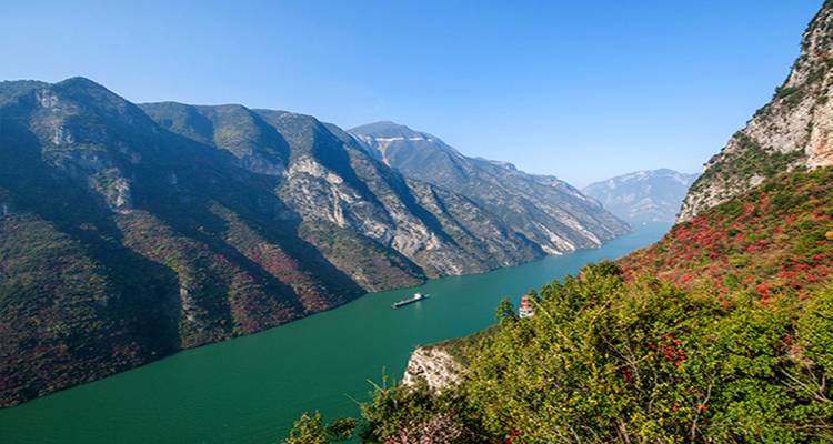Navire voyageant le long d'une rivière aux falaises majestueuses.
