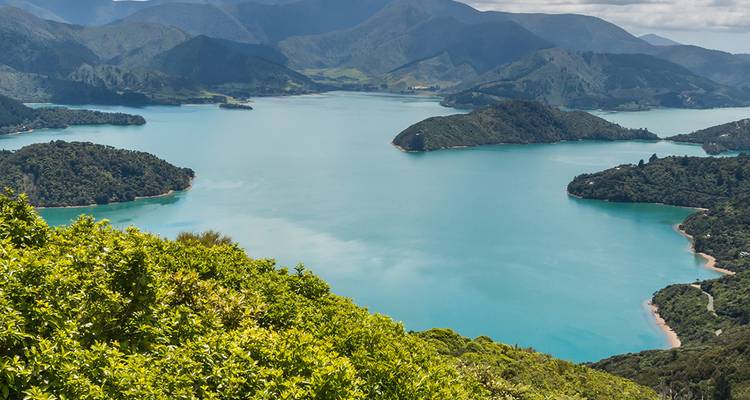 Aerial view of a calm blue lake surrounded by green hills.