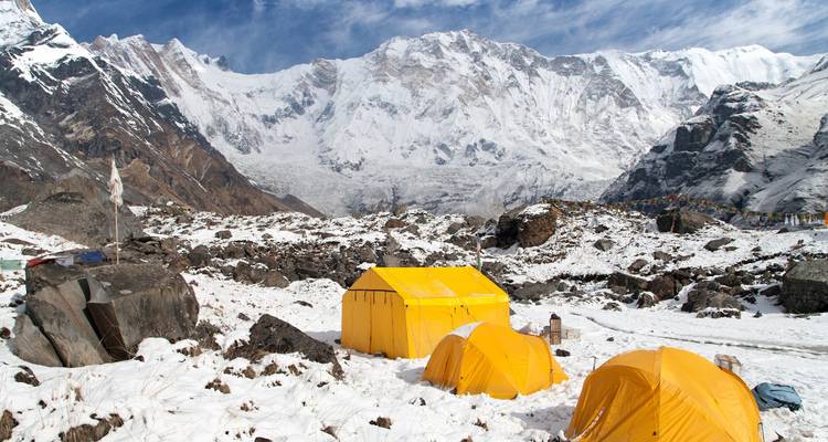 Zelte auf schneebedecktem Boden aufgebaut mit Blick auf das Annapurna-Gebirge.