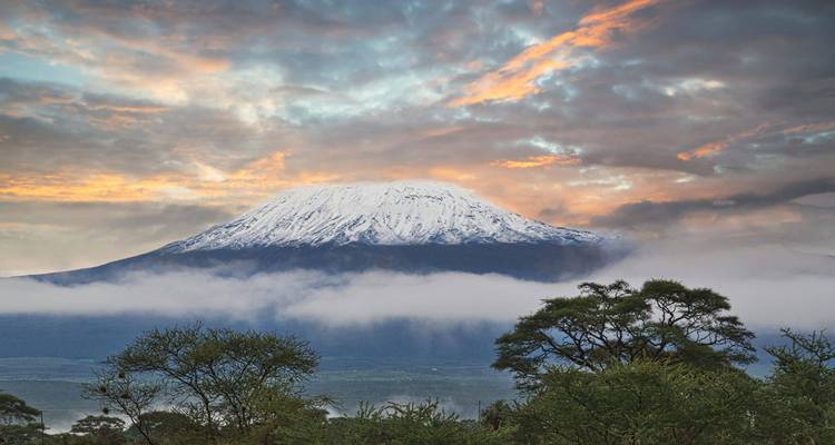 Mount Kilimanjaro during sunset with dramatic skies and clouds.