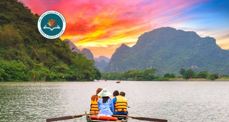 Mensen op een boot bij zonsondergang met bergen en een watermerk.