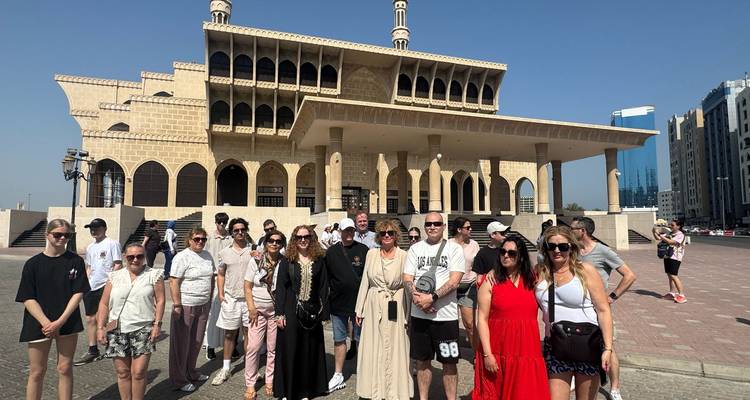 Groupe de touristes posant devant une mosquée.