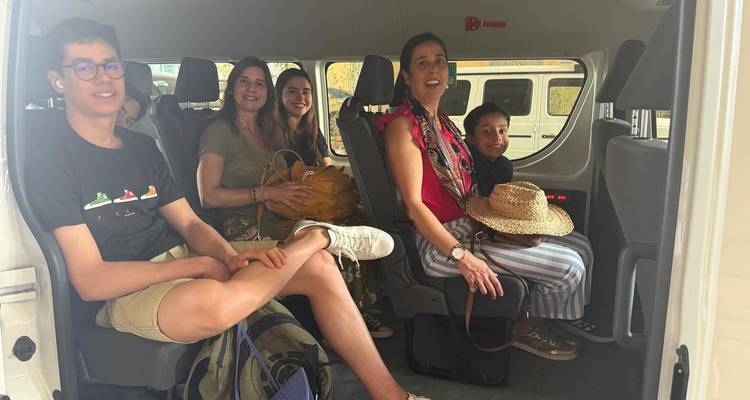 Des touristes assis à l'intérieur d'une camionnette.