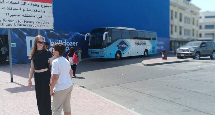 Des gens debout dans une rue à côté d'un bus touristique.