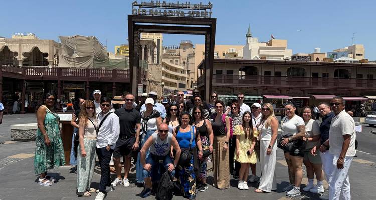 Grand groupe de touristes posant dans un marché.