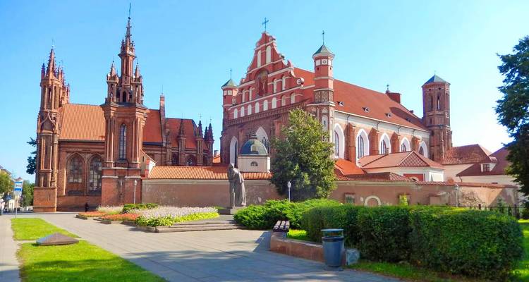 Blick auf eine historische Kirche mit lebendiger grüner Umgebung.