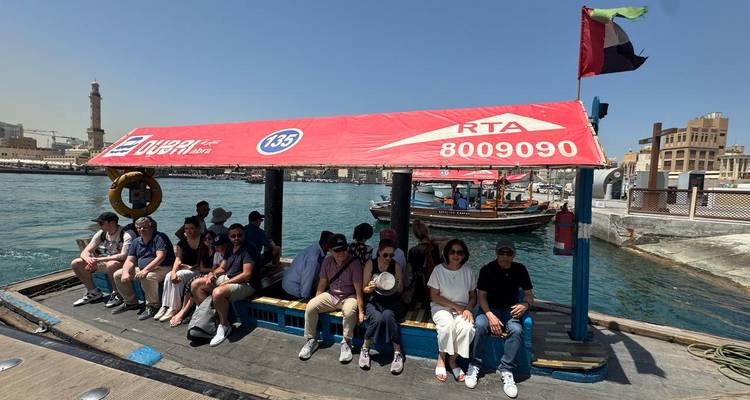 Passagers sur un taxi nautique avec des bâtiments de la ville au loin.