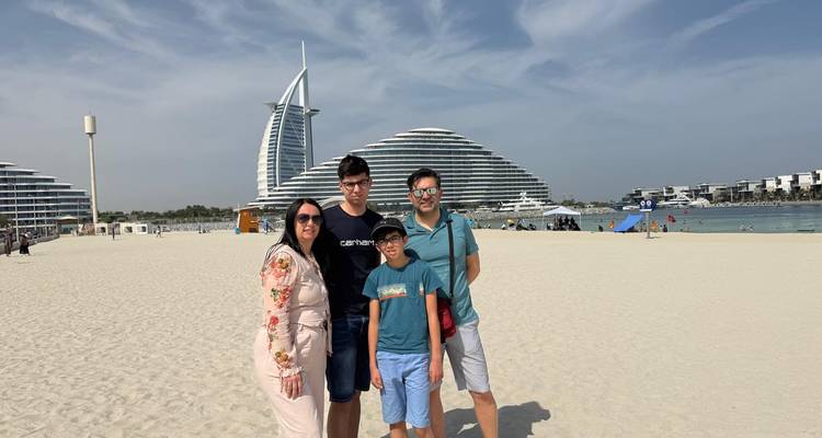 Famille sur la plage avec des bâtiments modernes emblématiques.