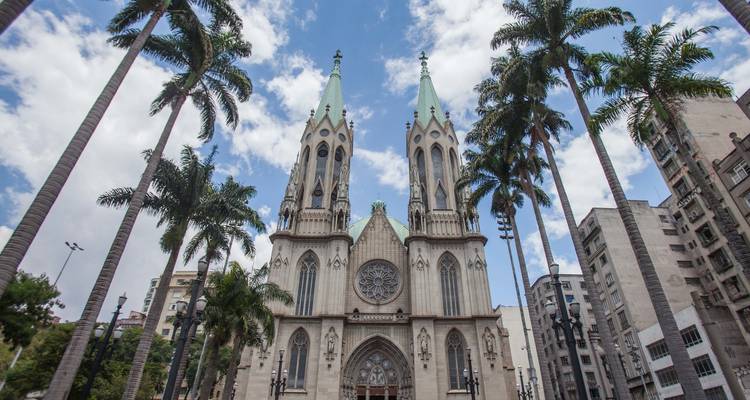 Imposing cathedral with tall palm trees.