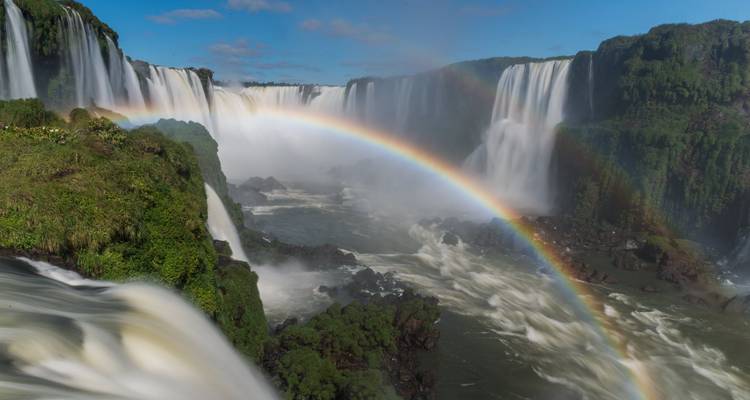 Waterfalls with rainbow and lush greenery.
