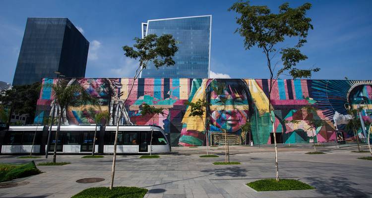 Vibrant street art mural in Rio de Janeiro with skyscrapers in the backdrop.