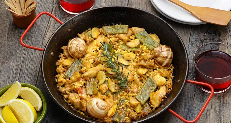Traditional Spanish paella dish with snails and vegetables.