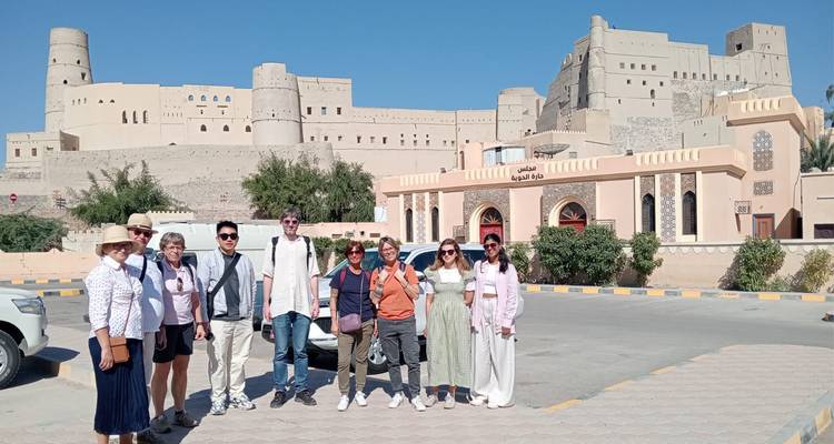 Turistas frente a un fuerte histórico durante el día.