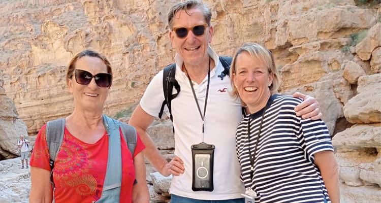 Tres personas sonriendo en un entorno de cañón.