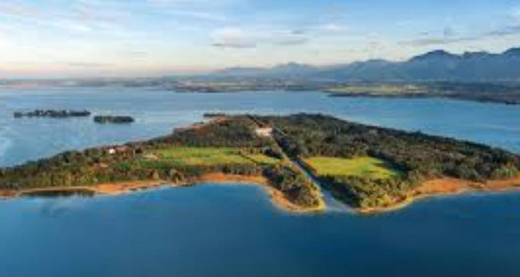 Aerial view of an island with clear blue waters and green fields.