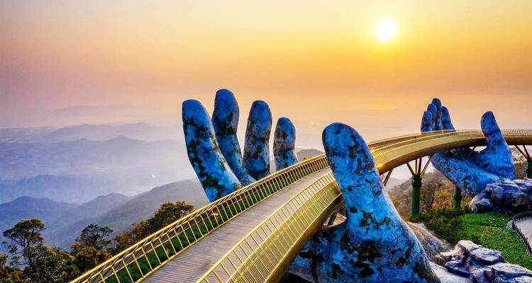 Pont doré soutenu par des mains géantes avec un coucher de soleil en arrière-plan.