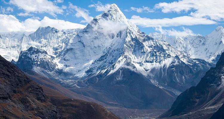 Majestueuse chaîne de montagnes enneigées sous un ciel dégagé.