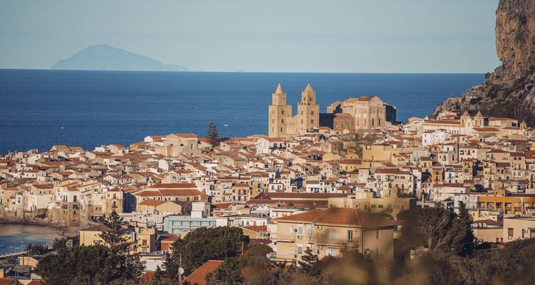 Panoramisch uitzicht op Cefalù met de oceaan en historische gebouwen.