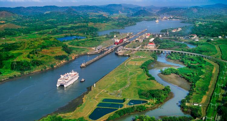 Aerial view of the Panama Canal with a cruise ship passing through.