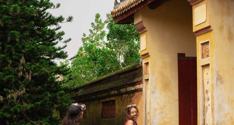 Deux personnes dans un temple ancien dans un cadre de jardin luxuriant.