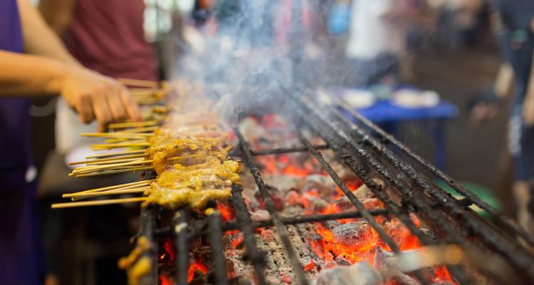 Skewered meat grilling over hot coals.