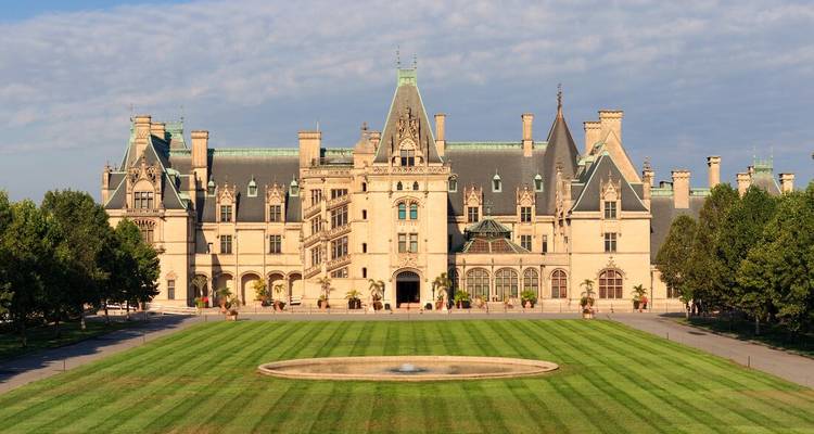 A grand historic mansion with a well-manicured lawn.