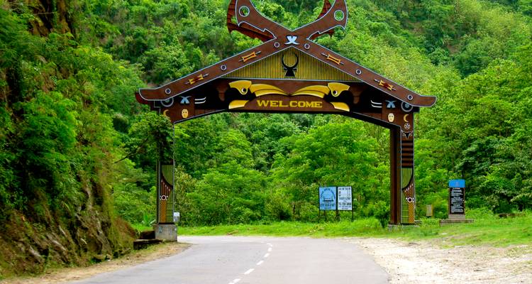 Decorative archway on a road with greenery.