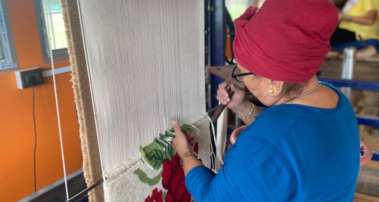 Femme travaillant sur un métier à tisser traditionnel dans un atelier textile.