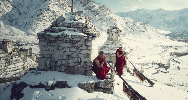 Moines sur une montagne enneigée avec des stupas.