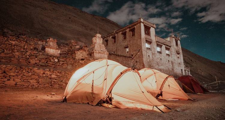Tentes installées près d'un bâtiment historique la nuit.