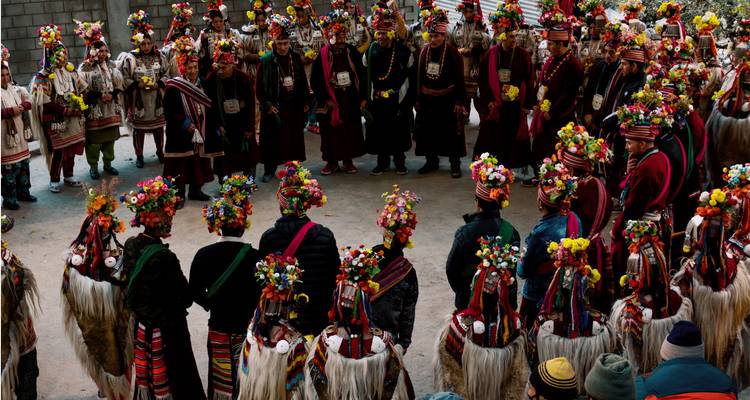 Groupe de personnes en costume traditionnel formant un cercle.