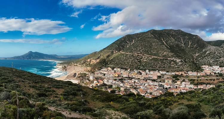 Village côtier le long d'un rivage montagneux.