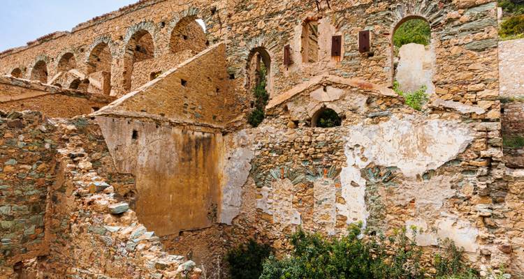 Ancien bâtiment en pierre avec des arcs et des murs patinés.