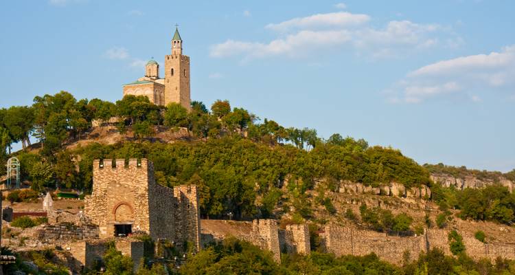 Forteresse de Tsarevets et église au sommet d'une colline verdoyante sous un ciel bleu dégagé.